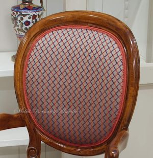 Poltroncina con braccioli in legno di noce con seduta e schienale imbottiti